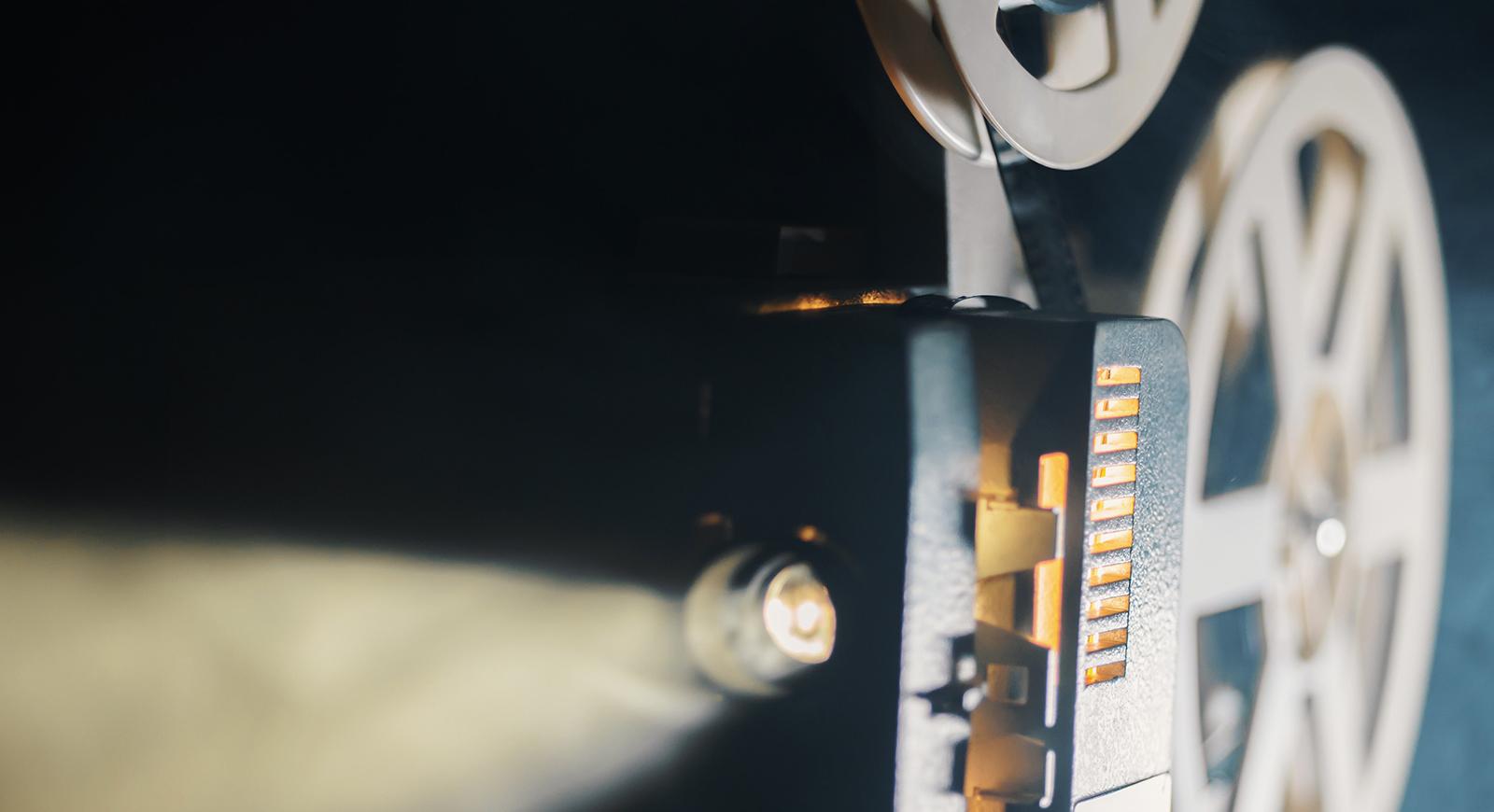 一个老式放映机的特写照片，光线通过胶卷卷. 